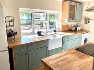 a kitchen with blue cabinets and a counter top at Holly Tree Cottage - 3 bedrooms and large garden with optional glamping double outside in Lymington