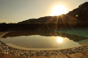 a body of water with the sun in the background w obiekcie Agriturismo San Cataldo w mieście Motta Camastra
