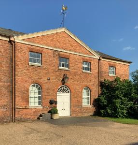 a red brick building with a white door at The Stables Apartment in Newark-on-Trent