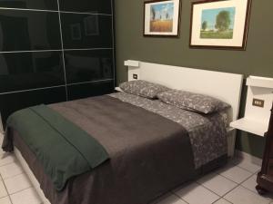 una camera da letto con un letto con una coperta grigia di 3per3 a Busto Arsizio