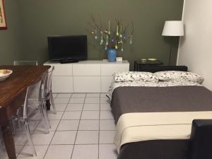 a bedroom with a bed and a desk with a television at 3per3 in Busto Arsizio