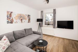 a living room with a couch and a flat screen tv at Leonhardsblick Appartements in Tamsweg
