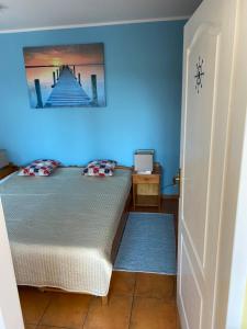 a bedroom with a bed and a blue wall at Apartman Delfin in Senec