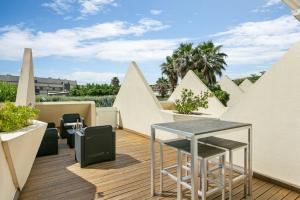d'un balcon avec une table et des murs blancs. dans l'établissement Village Naturiste - Le Diamond X Héliopolis Luxe, au Cap d'Agde