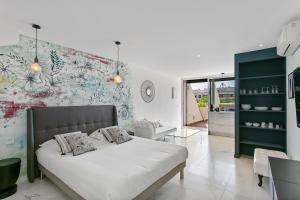 - une chambre avec un lit et un mur orné de fleurs dans l'établissement Village Naturiste - Le Diamond X Héliopolis Luxe, au Cap d'Agde