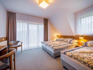 une chambre d'hôtel avec deux lits et une chaise dans l'établissement Strama Kościelisko, à Kościelisko
