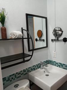 a bathroom with a sink and a mirror and a toilet at Hotel Casa Aurora in Querétaro