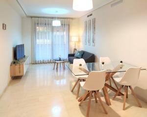 - un salon avec une table en verre et des chaises blanches dans l'établissement Tu Casa en Jávea, à Jávea