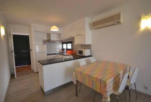a kitchen with a table and a table and chairs at Stupendo Appartamento a Cala’n Bosch Minorca in Cala'n Bosch +18 photos