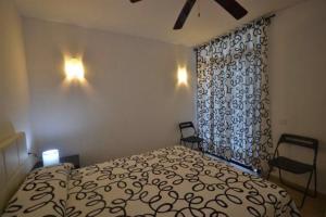 a bedroom with a bed and two chairs and a window at Stupendo Appartamento a Cala’n Bosch Minorca in Cala'n Bosch