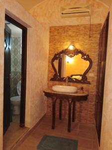 Nouveau Bungalow Djerba في حومة السوق: حمام مع حوض ومرآة