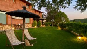 a lawn with two chairs and an umbrella at El Balcón De Alboreca in Alboreca