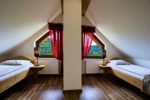 2 Betten in einem Zimmer mit 2 Fenstern in der Unterkunft Apartamenty na Pienińskim Wzgórzu in Szczawnica