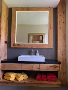ein Badezimmer mit einem Waschbecken, einem Spiegel und Handtüchern in der Unterkunft Statek Topelec Apartman II in Písek