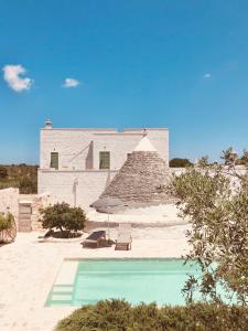 a house with a swimming pool in front of a building at Masseria Fenicia in Monopoli