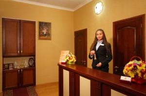 a woman standing next to a counter in a room at Ekaterina Hotel in Odesa