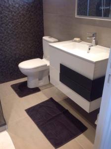 een badkamer met een witte wastafel en een toilet bij Canadian Beach Hut in Bénerville-sur-Mer
