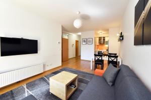 een woonkamer met een bank en een tv bij BLOCK APARTMENT PARK with private garage parking in Zagreb
