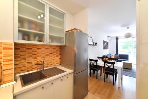 een keuken met een roestvrijstalen koelkast en een eetkamer bij BLOCK APARTMENT PARK with private garage parking in Zagreb