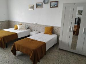 a hotel room with two beds and a mirror at Casa de pueblo cerca de Gredos y Navaluenga in Navalmoral