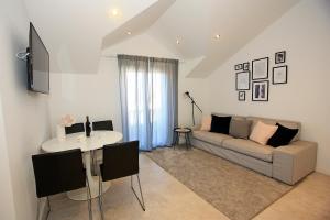 ein Wohnzimmer mit einer Couch und einem Tisch in der Unterkunft Apartman Ivana in Supetar