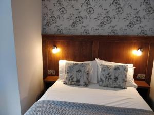 a bedroom with a bed with two pillows at Arkle House in Pennyburn
