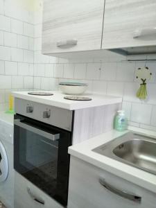 uma cozinha com um lavatório e uma bancada em Montedarena SILVER - A due passi dal mare em Pulsano