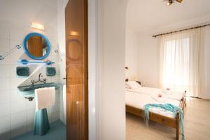 une petite chambre avec un lit et un lavabo dans l'établissement CHRISTOS STUDIOS, à Laganas