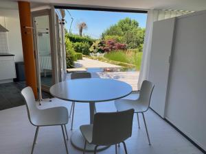 a table and chairs in a room with a patio at Leen & Bruno's NamaStay in Grez-Doiceau