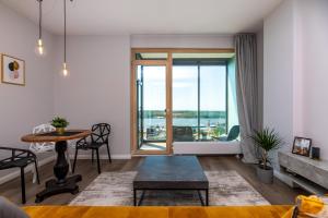 a living room with a table and a large window at Modern spacious studio w/ Sea Views in Klaipėda
