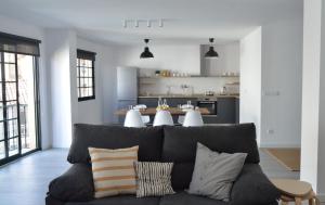 a living room with a gray couch and a kitchen at Os Faros Pisos Turísticos in Arou
