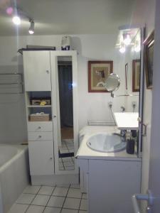 La salle de bains est pourvue d'un lavabo, d'un miroir et d'une baignoire. dans l'établissement ART APPART KEMPER, à Quimper