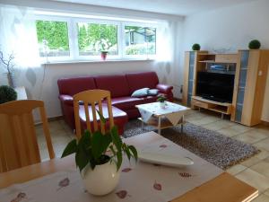 sala de estar con sofá rojo y mesa en ferienwohnung-land en Sankt Ingbert