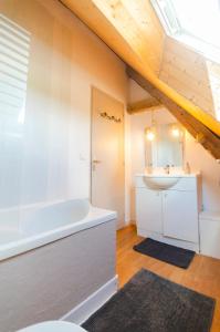 a bathroom with a white tub and a sink at la ferme des epis in Ouffières