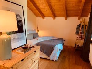 a bedroom with a bed and a table with a lamp at Mountainhome Birringer in Marktschellenberg