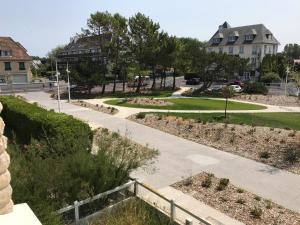 una pasarela en un barrio residencial con casas en Les Alisés, en Merville-Franceville-Plage