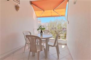 een eetkamer met een tafel en stoelen en een raam bij Adalena Oura By ALzira in Albufeira