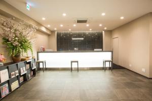 a large waiting room with a white counter and two stools at Kuretake Inn Nagoya Hisayaodori in Nagoya