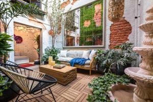 a patio with a couch and a table and chairs at Casa Kanabri Hostal Boutique in Mexico City