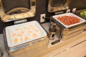 a buffet with two trays of food on a counter at Kuretake Inn Nagoya Hisayaodori in Nagoya