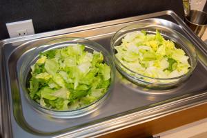 two glass bowls of lettuce on a microwave at Kuretake Inn Nagoya Hisayaodori in Nagoya