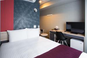 a bedroom with a bed and a desk with a computer at Kuretake Inn Nagoya Hisayaodori in Nagoya