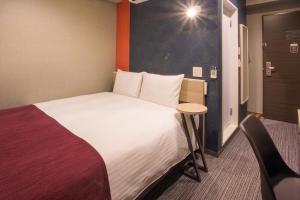 a hotel room with a large bed and a table at Kuretake Inn Nagoya Hisayaodori in Nagoya