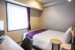 a hotel room with a bed and a window at Kuretake Inn Nagoya Hisayaodori in Nagoya