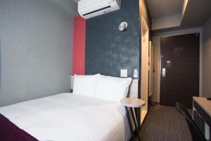a bedroom with a bed with a red wall at Kuretake Inn Nagoya Hisayaodori in Nagoya