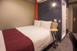 a hotel room with a large bed and a table at Kuretake Inn Nagoya Hisayaodori in Nagoya