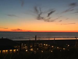 una puesta de sol en la playa con luces en la arena en Pension Marco, en Zandvoort