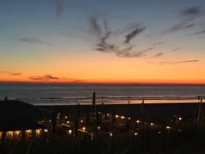 a sunset at the beach with lights on the sand at Pension Marco in Zandvoort