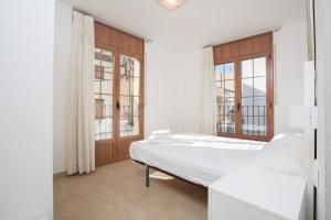 ein weißes Schlafzimmer mit einem Bett und einem Fenster in der Unterkunft Apt Costa Dorada 2 by MarCalma in Creixell