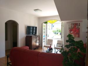 - un salon avec un canapé rouge et une télévision dans l'établissement Casa Grande, à Florianópolis